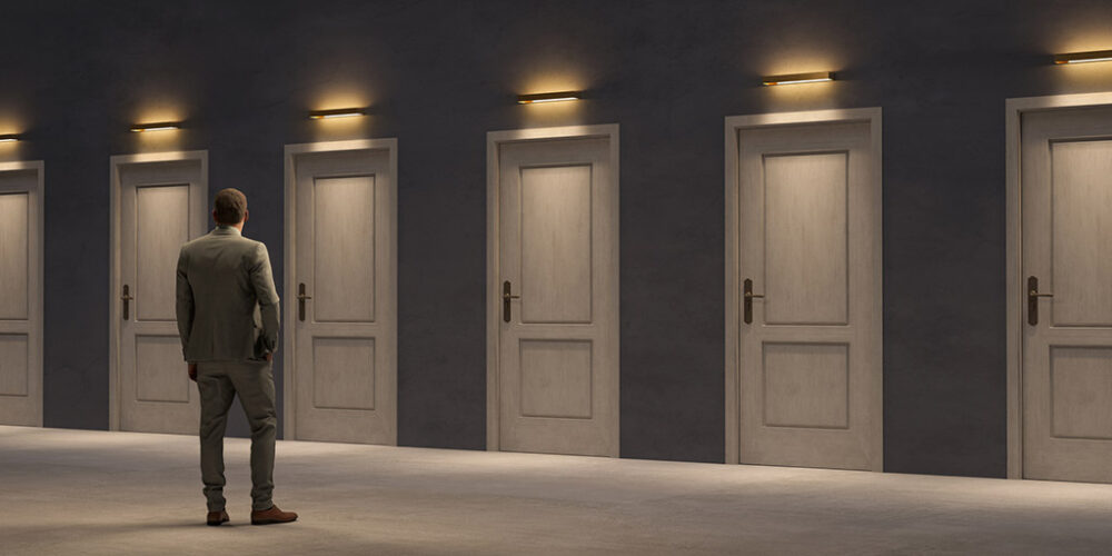 Man standing in front of several closed doors